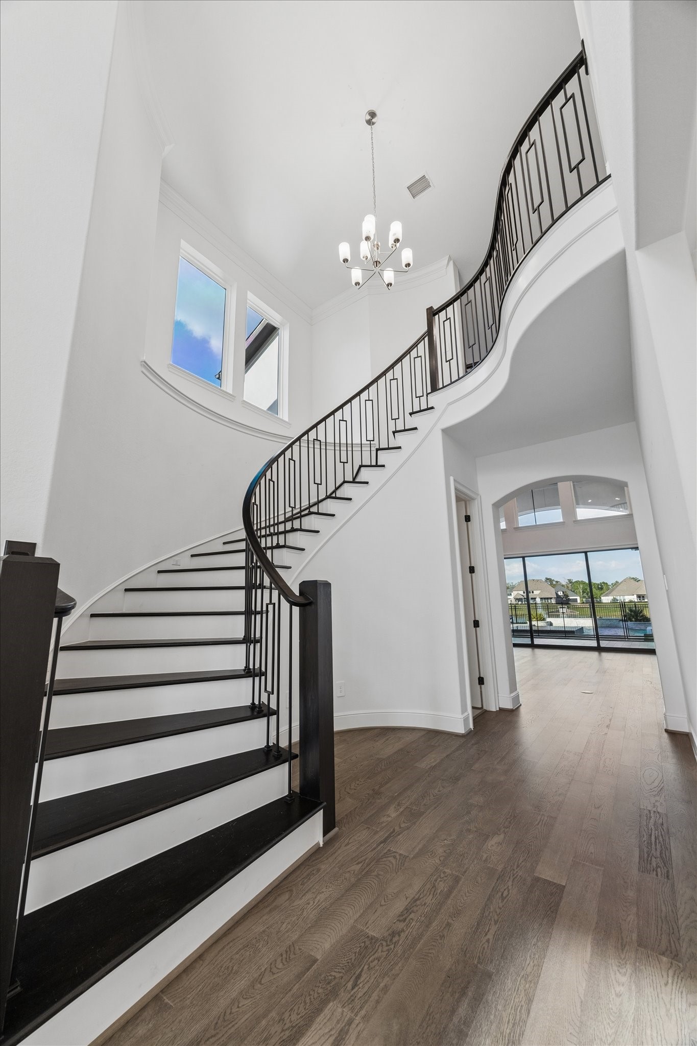 28015 Royal Swan Lane Spring, TX 77386 - Photo 5 of 25 Impressive two-story foyer featuring a dramatic curved staircase, elegant railing, soaring ceilings, and abundant natural light, creating a stunning architectural statement upon entry.