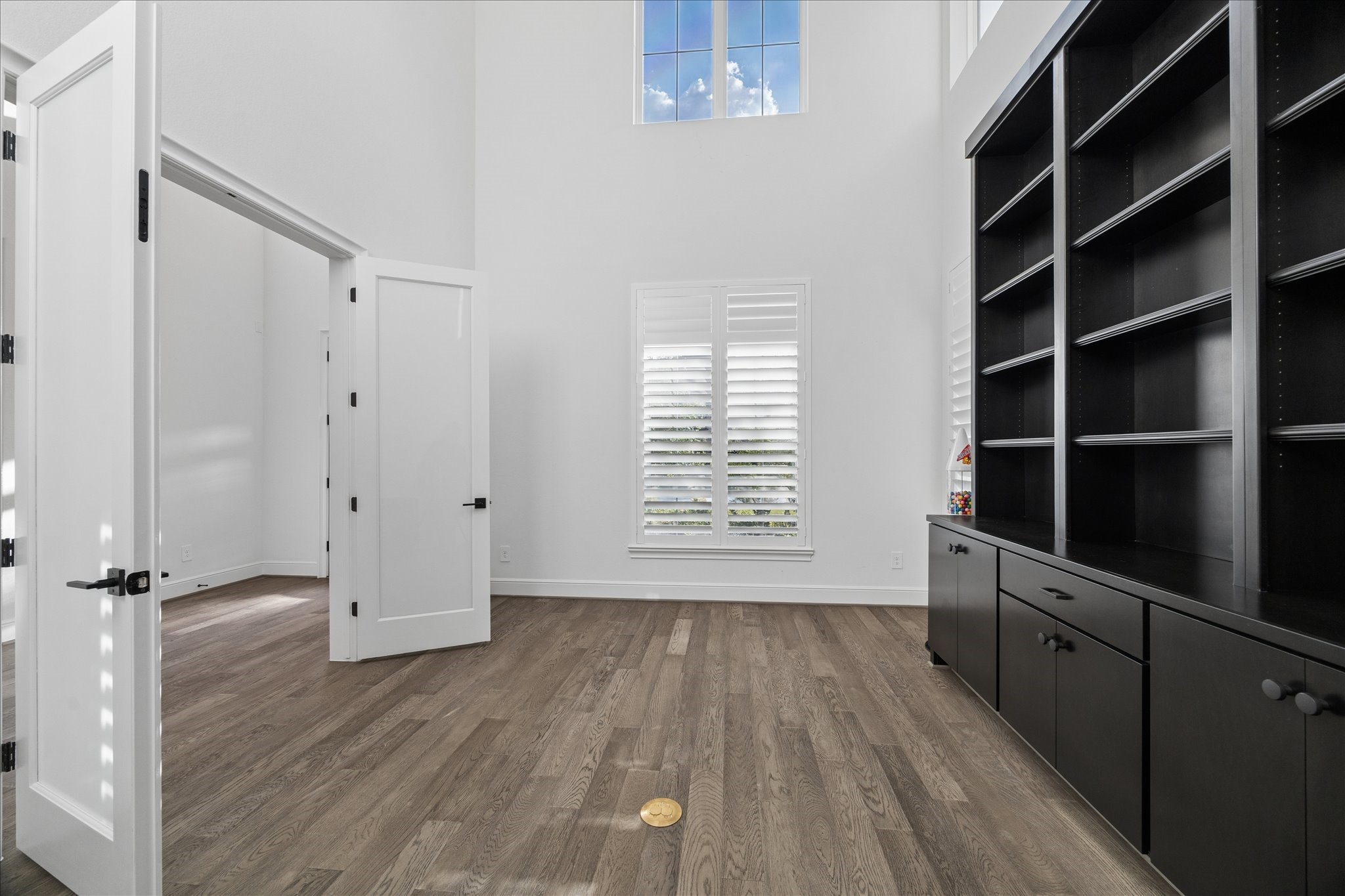 28015 Royal Swan Lane Spring, TX 77386 - Photo 7 of 25 Spacious study featuring soaring ceilings, rich wood flooring, large windows that bring in natural light, and custom built-in shelving, creating an ideal space for a private office or library.