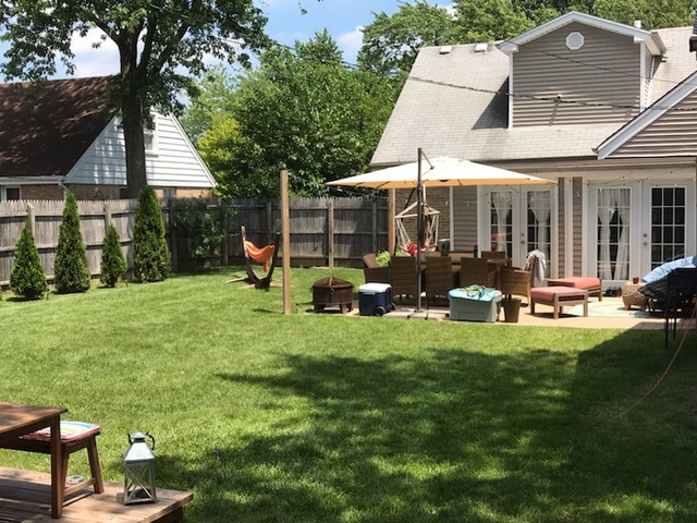 10906 Parkside Avenue Chicago Ridge, IL 60415 - Photo 15 of 15 a view of a backyard with table and chairs under an umbrella