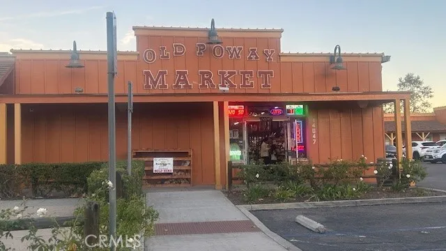 a front view of a building with trees and retail shops