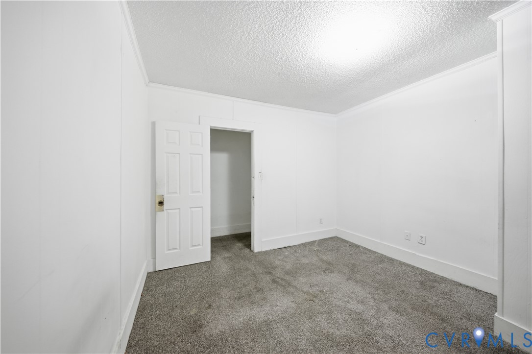 27 Bacon Street Hampton, VA 23669 - Photo 7 of 18 Empty room with dark colored carpet, a textured ce