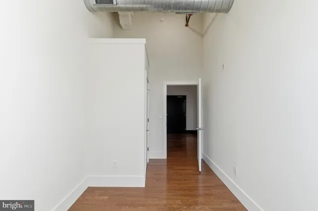 a view of a hallway with wooden floor