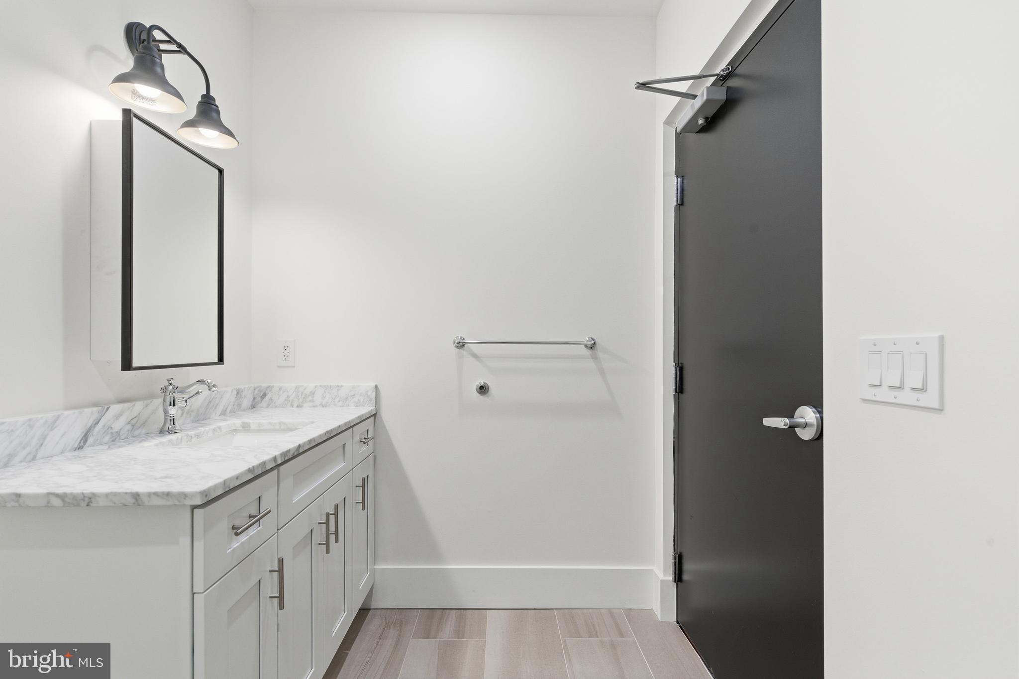 1801 North Howard Street, Unit C04 Philadelphia, PA 19122 - Photo 13 of 22 a bathroom with a sink a mirror and a shower
