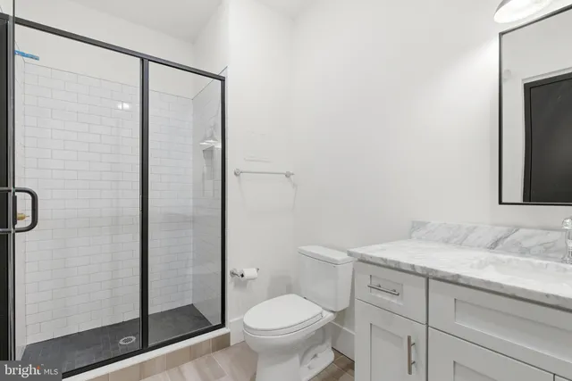 a bathroom with a granite countertop sink toilet and shower