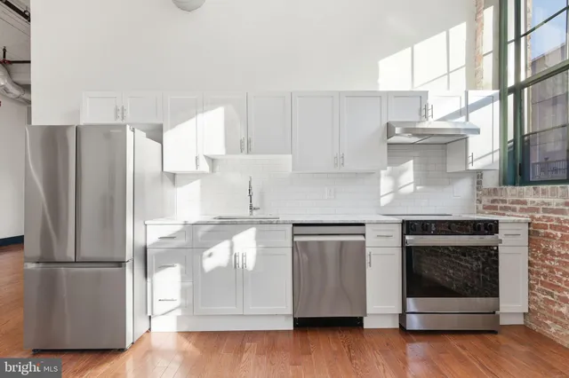 a kitchen with stainless steel appliances granite countertop a refrigerator and a stove