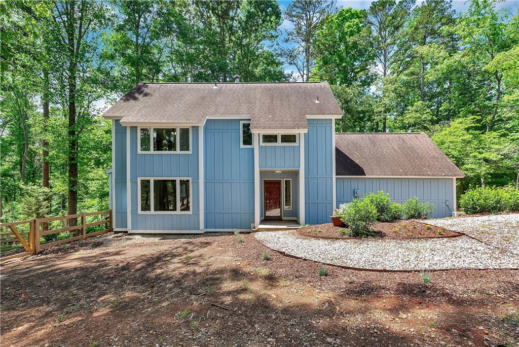 1298 Carradine Road Seneca, SC 29678 - Photo 1 of 43 A striking blue facade nestled amongst mature trees creates an inviting retreat.