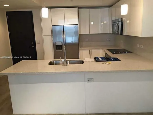 a kitchen with a sink a refrigerator and cabinets
