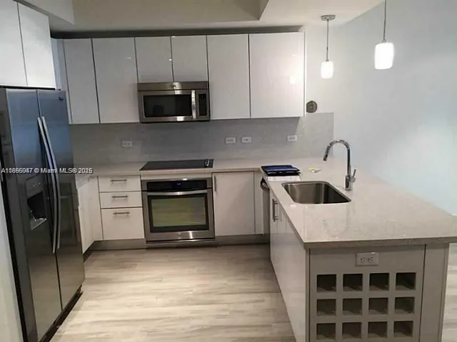a kitchen with a sink and a stove top oven