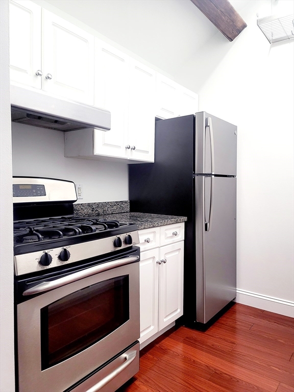 42 8th Street, Unit 2515 Boston, MA 02129 - Photo 11 of 29 a kitchen with granite countertop a stove and a refrigerator