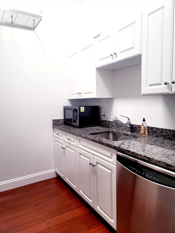 42 8th Street, Unit 2515 Boston, MA 02129 - Photo 12 of 29 a kitchen with granite countertop a sink cabinets and stainless steel appliances