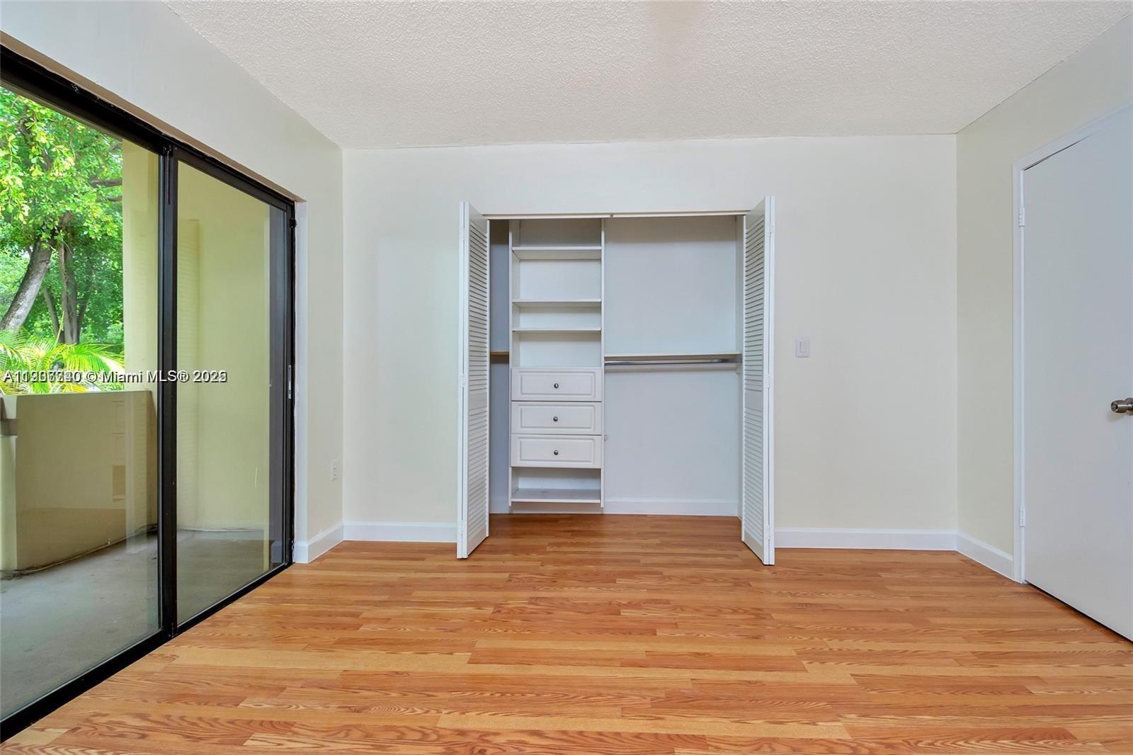 6236 Southwest 136th Court, Unit B105 Miami, FL 33183 - Photo 18 of 22 a view of an empty room with wooden floor and a window