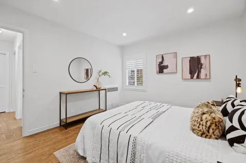 a bedroom with a bed a mirror and a window