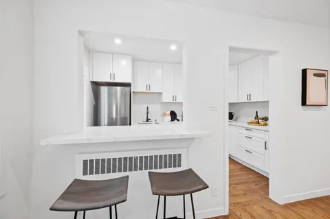 a kitchen with a refrigerator and a chair