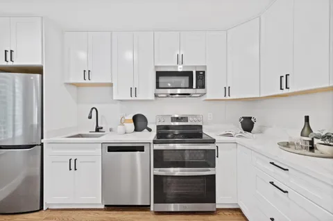 a kitchen with stainless steel appliances granite countertop a sink stove and refrigerator