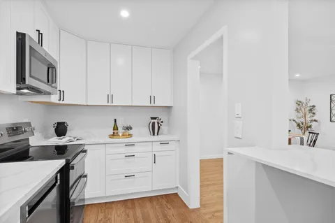 a kitchen with stainless steel appliances a sink stove and cabinets