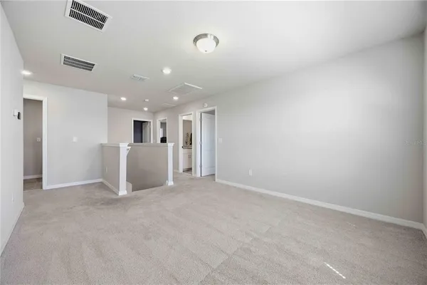 a view of a big room with kitchen and windows