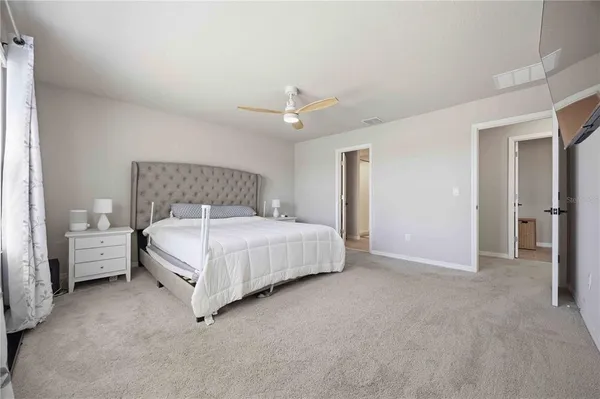 a bedroom with a bed and a ceiling fan