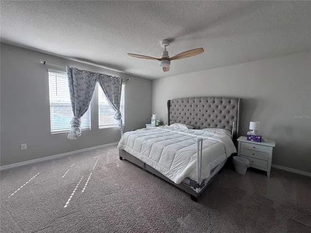 a bedroom with a bed and large windows