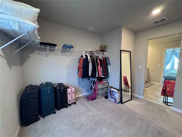a view of walk in closet with clothes and shoes