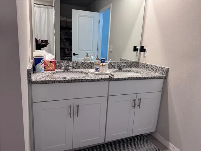 a bathroom with a granite countertop sink and a mirror