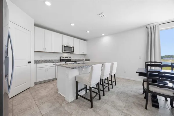 a kitchen with appliances cabinets and chair