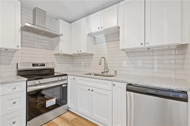 a kitchen with granite countertop white cabinets and white appliances