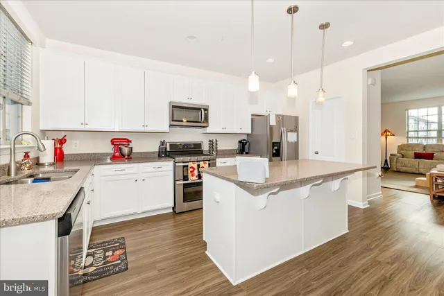 a kitchen with kitchen island granite countertop a sink appliances and cabinets