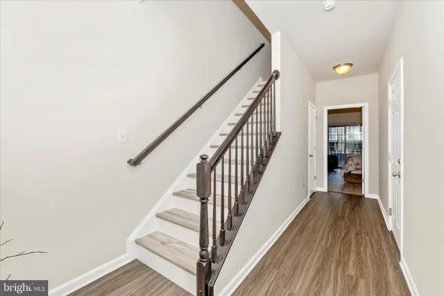 a view of a hallway with wooden floor and staircase