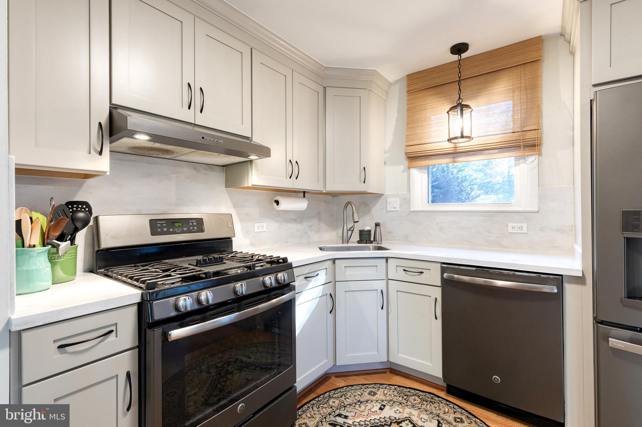 1 North Hilltop Road Baltimore, MD 21228 - Photo 19 of 36 a kitchen with granite countertop white cabinets appliances and a window