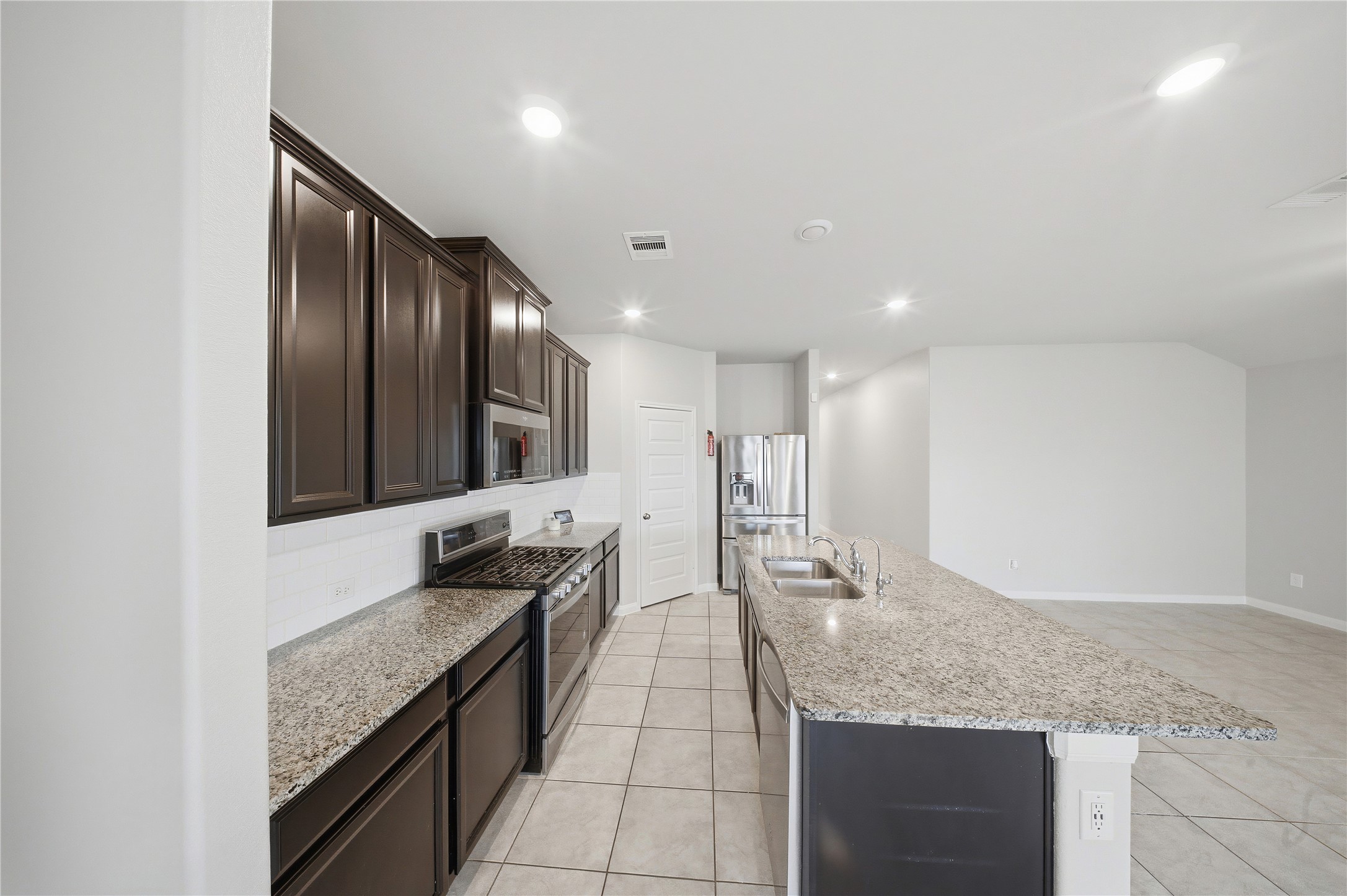 815 Barstow Drive Rosharon, TX 77583 - Photo 4 of 23 Spacious kitchen featuring granite countertops, dark cabinetry, stainless steel appliances, and a large island.
