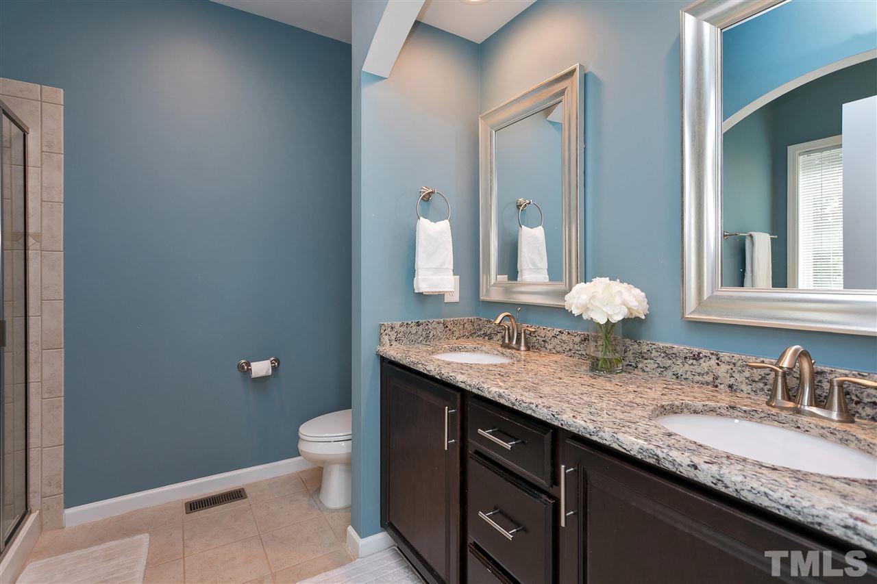 5639 Wade Park Boulevard Raleigh, NC 27607 - Photo 13 of 24 a bathroom with a granite countertop sink a toilet and a mirror