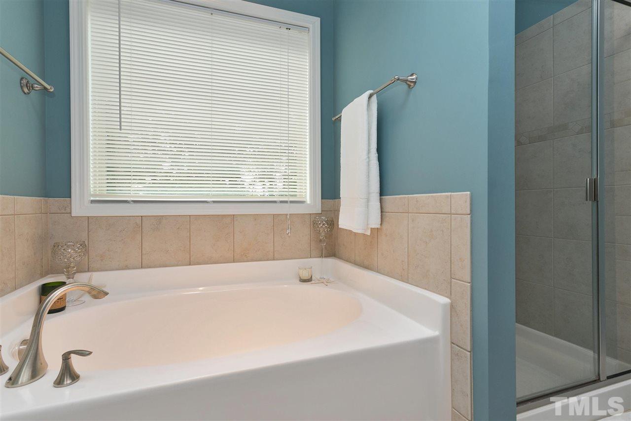 5639 Wade Park Boulevard Raleigh, NC 27607 - Photo 14 of 24 a white bath tub sitting in a bathroom next to a window