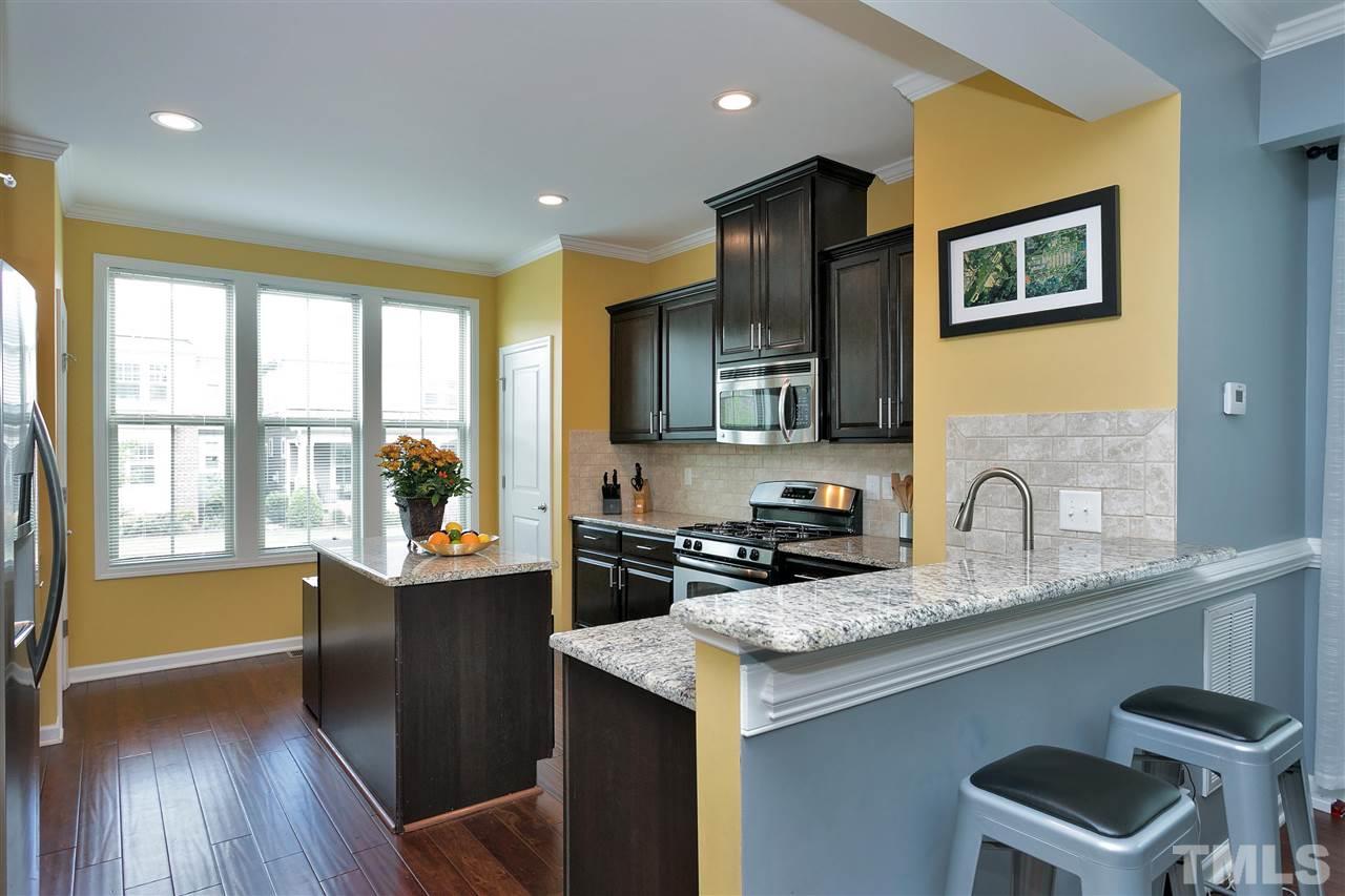 5639 Wade Park Boulevard Raleigh, NC 27607 - Photo 3 of 24 a kitchen with granite countertop a stove a sink a refrigerator wooden floor and cabinets