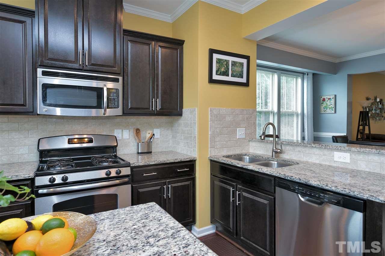 5639 Wade Park Boulevard Raleigh, NC 27607 - Photo 4 of 24 a kitchen with granite countertop stainless steel appliances and wooden cabinets