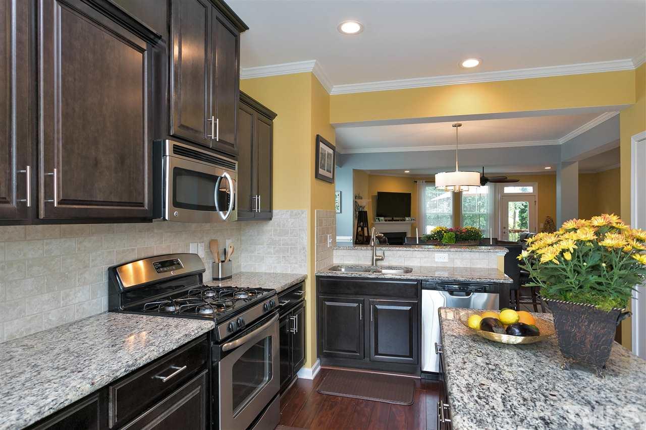 5639 Wade Park Boulevard Raleigh, NC 27607 - Photo 5 of 24 a kitchen with stainless steel appliances granite countertop a stove a sink and a microwave