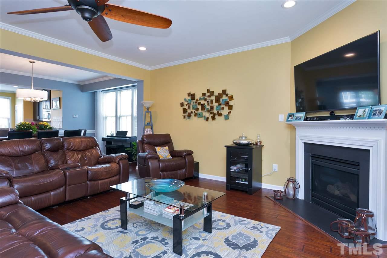 5639 Wade Park Boulevard Raleigh, NC 27607 - Photo 9 of 24 a living room with furniture a flat screen tv and a fireplace