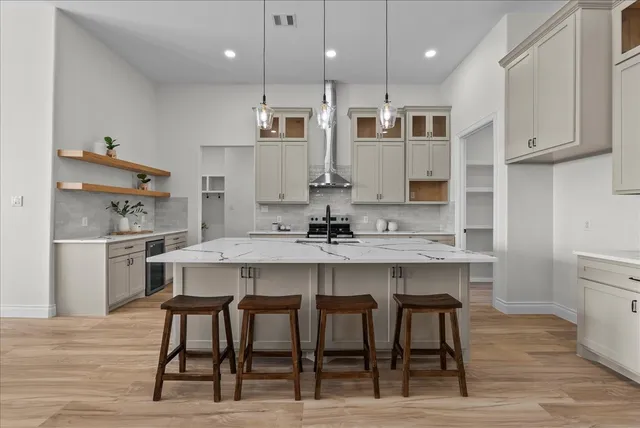 a kitchen with kitchen island granite countertop a sink and white cabinets