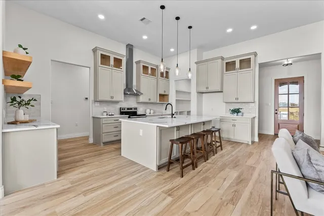 a dining room with wooden floor a chandelier a wooden table and chairs