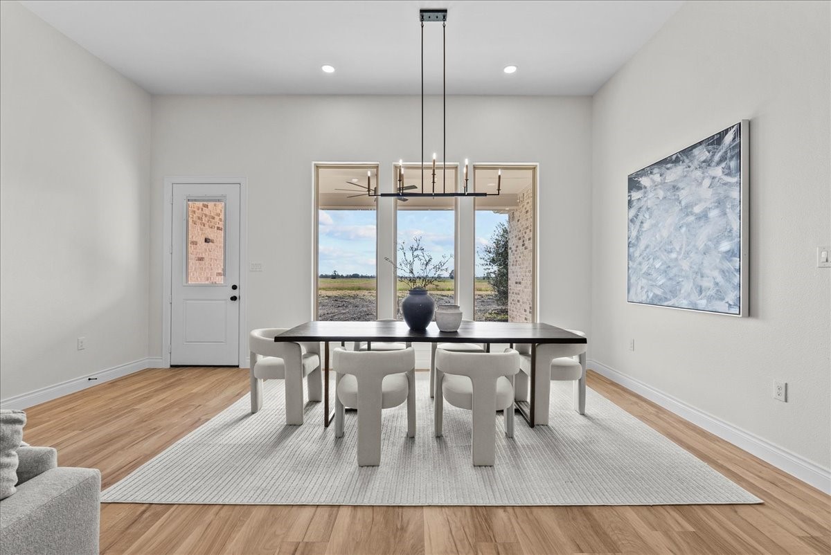 224 Cripple Creek Lane Angleton, TX 77515 - Photo 18 of 38 a dining room with wooden floor a glass table and chairs