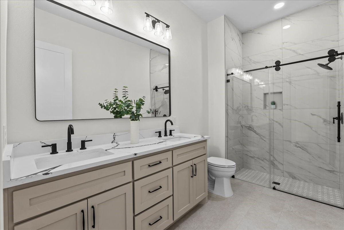 224 Cripple Creek Lane Angleton, TX 77515 - Photo 33 of 38 a bathroom with double sink a toilet a shower and a mirror
