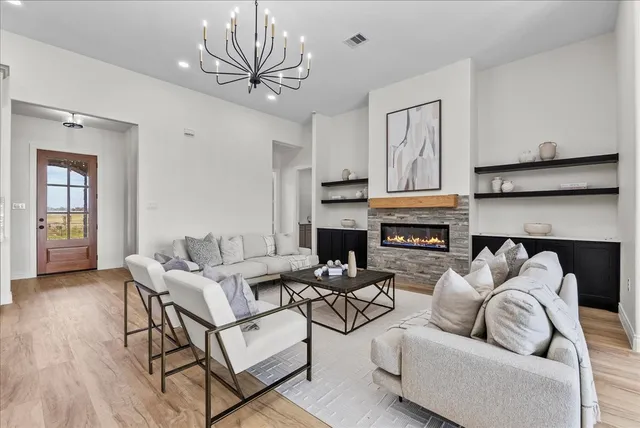 a living room with furniture a fireplace and a ceiling fan