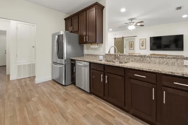 a kitchen with stainless steel appliances granite countertop a refrigerator and a sink