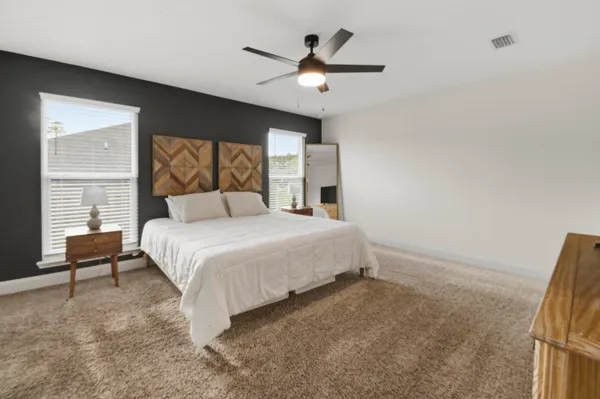 a bedroom with a large bed and a chandelier