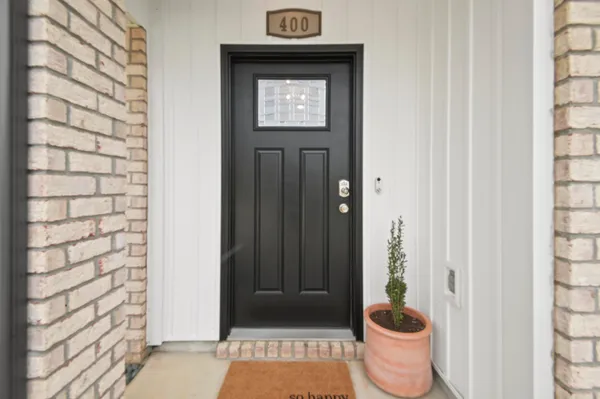 a view of a hallway with wooden floor and a potted plant