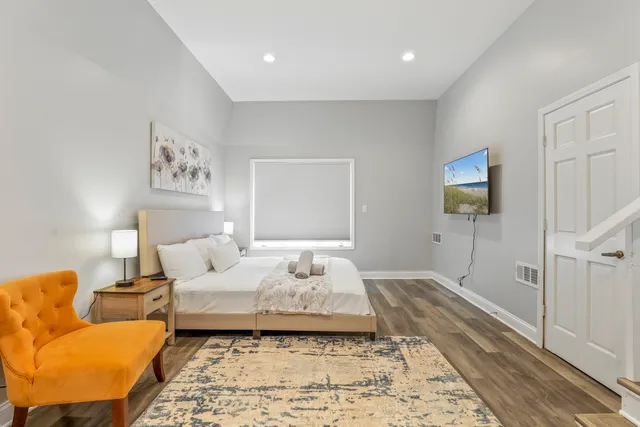 a bedroom with a bed and wooden floor