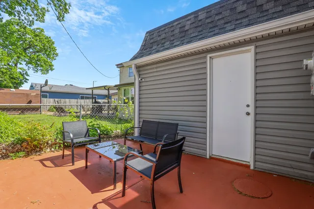 a view of a patio with a table and chairs next to a yard