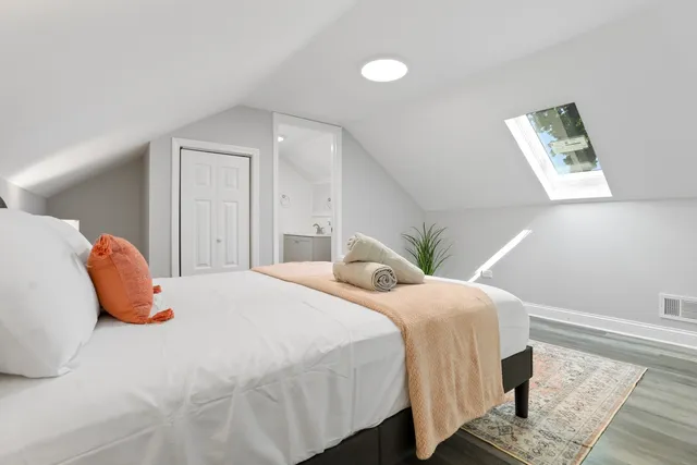 a bedroom with a bed and wooden floor