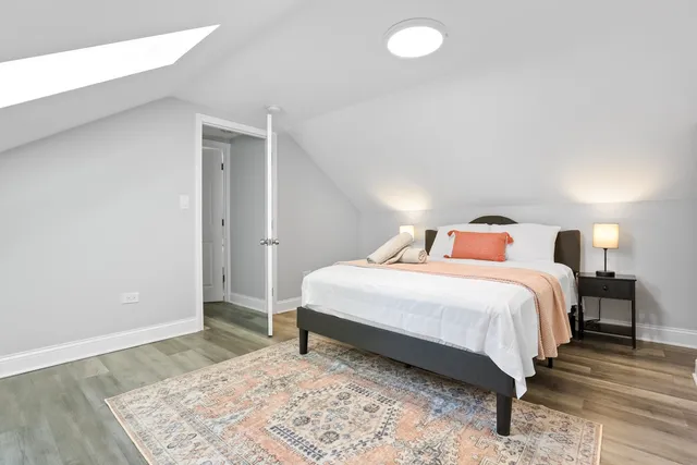 a bedroom with a bed and a wooden floor