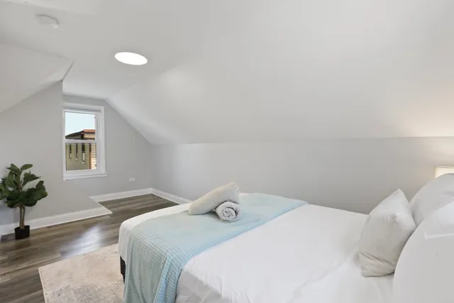 a bedroom with a bed and a potted plant