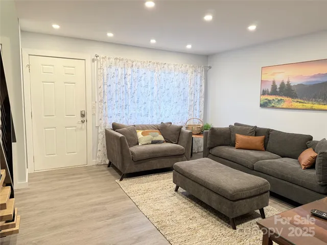 a kitchen with stainless steel appliances granite countertop a refrigerator a stove a sink a dining table and chairs